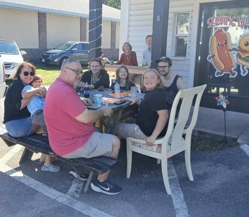 A family enjoying lunch at the picnic tables out front
